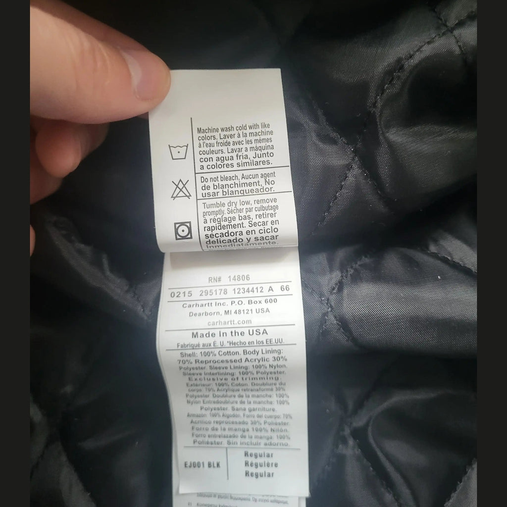 Étiquette d'une veste Carhartt brune taille L, instructions d'entretien visibles. Fripes Sélect