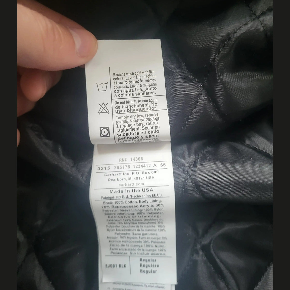Étiquette d'une veste Carhartt brune taille L, instructions d'entretien visibles. Fripes Sélect