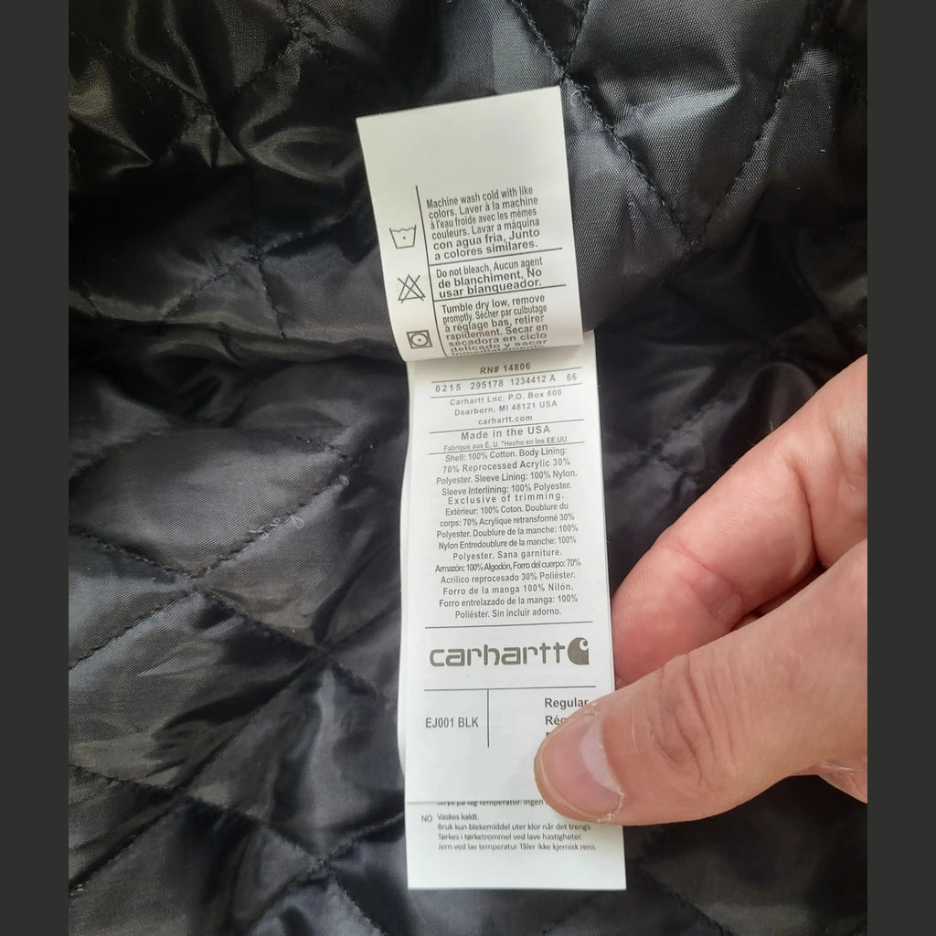 Veste Carhartt noire, taille Regular, intérieur matelassé, étiquette visible. Fripes Sélect
