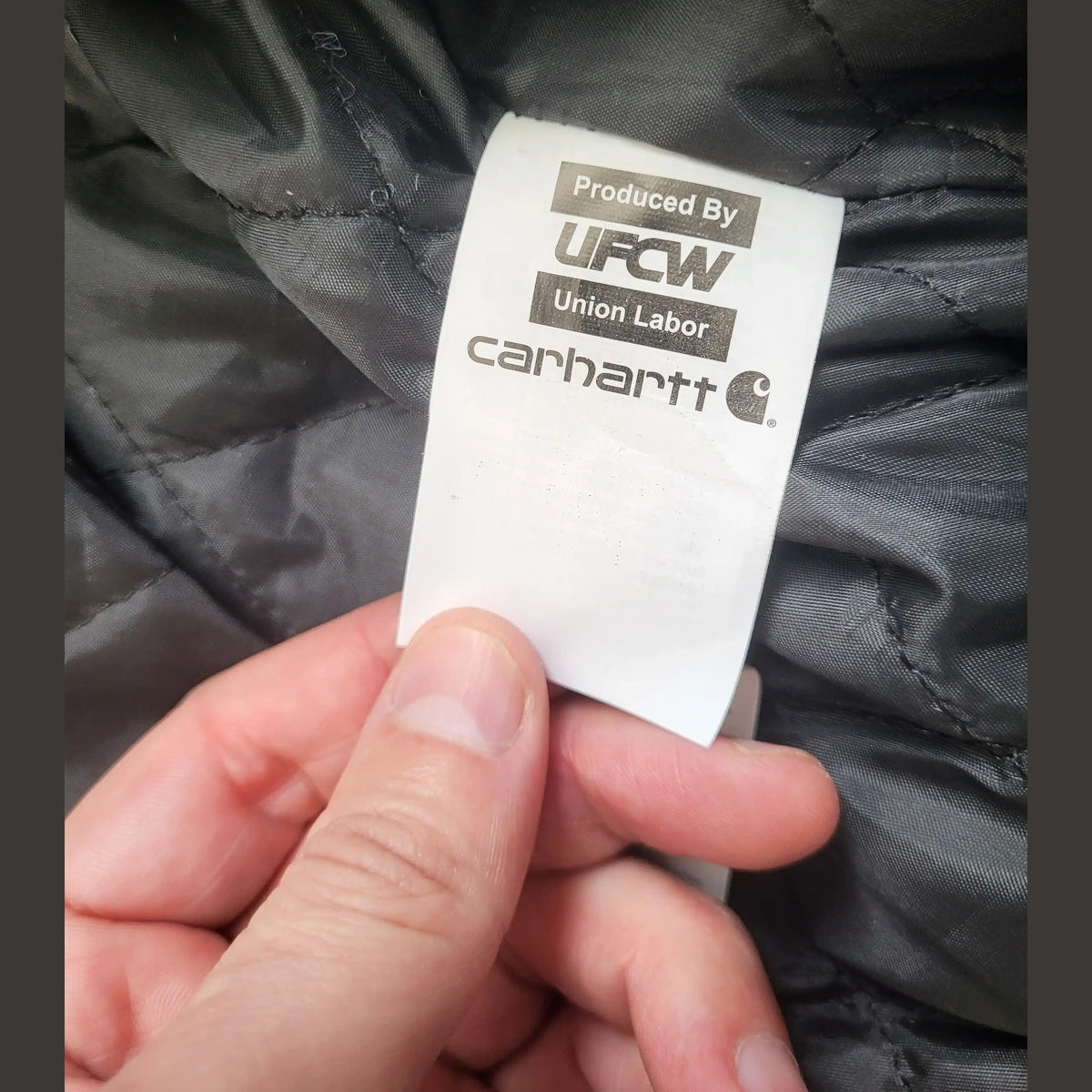 Étiquette d'une veste Carhartt kaki, taille M. Fripes Sélect