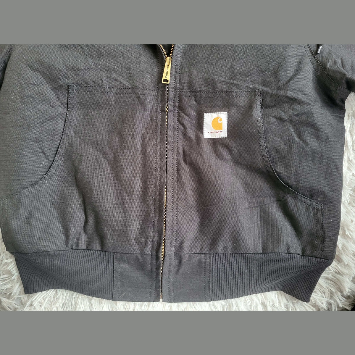 Veste Carhartt noire taille L, fermeture zippée, poche avant. Fripes Sélect