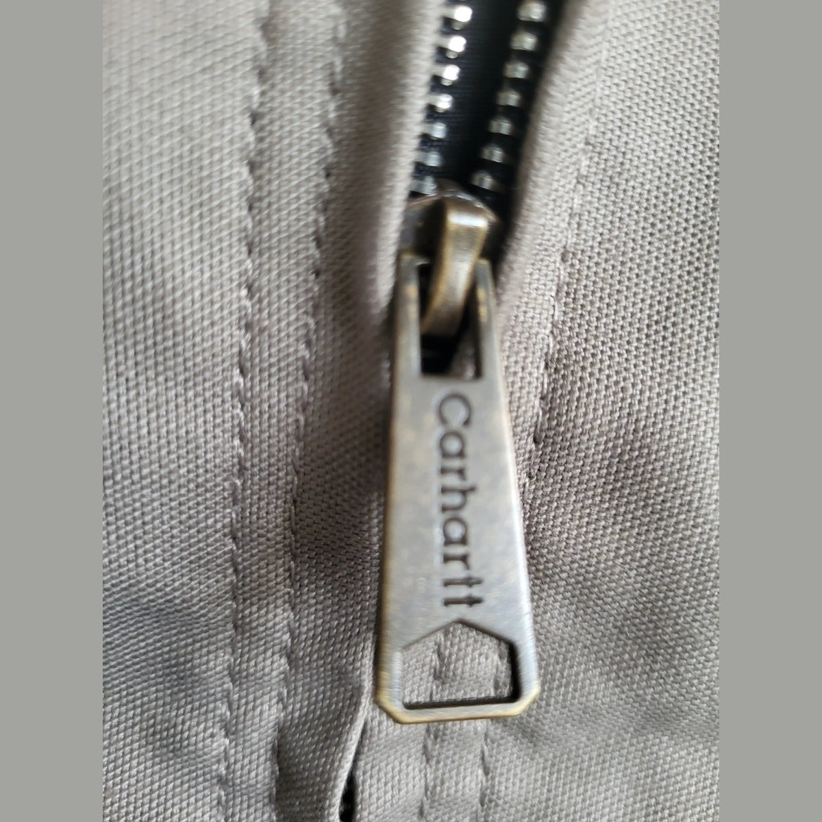 Veste Carhartt beige taille M, détail de la fermeture éclair. Fripes Sélect