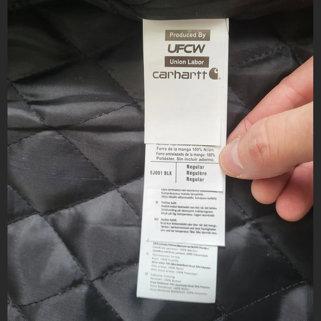 Veste Carhartt noire, taille Regular, étiquette intérieure visible. Fripes Sélect