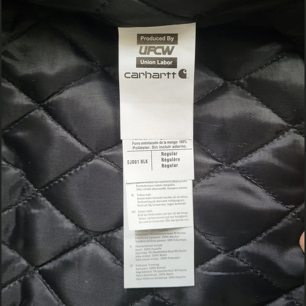 Veste Carhartt noire matelassée taille M, étiquette visible. Fripes Sélect