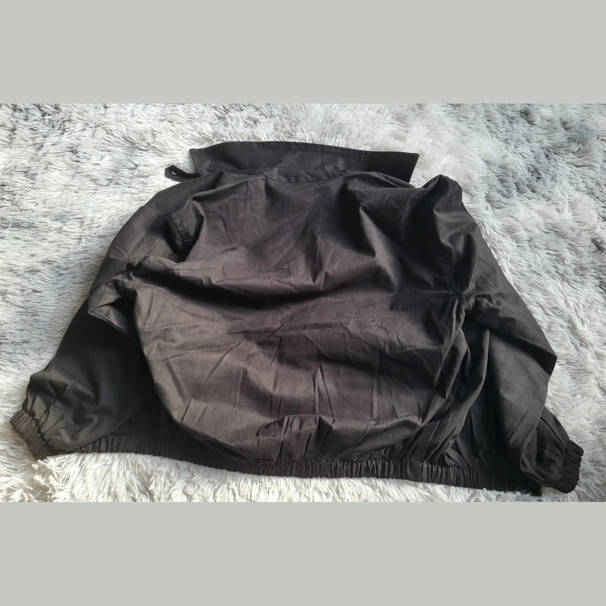 Veste Harrington noire Ralph Lauren taille M, posée sur un tapis. Fripes Sélect