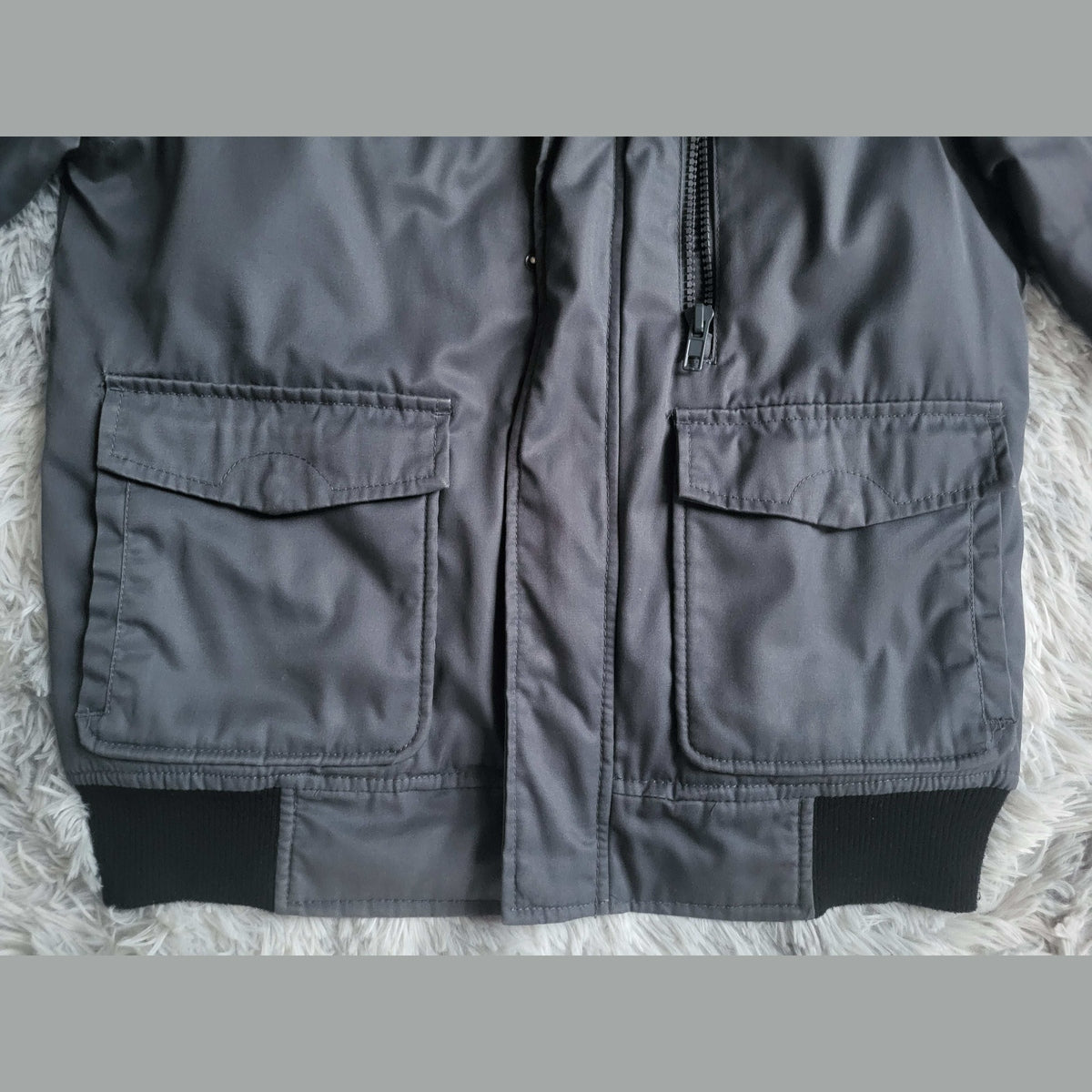 Veste grise, marque non visible, taille non indiquée, poches à rabat. Fripes Sélect