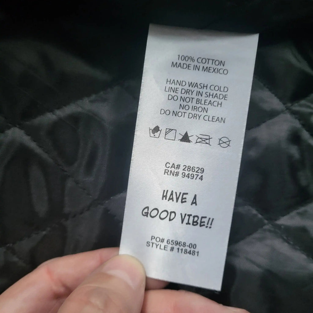Veste noire matelassée, étiquette visible, marque non indiquée, taille non visible. Fripes Sélect