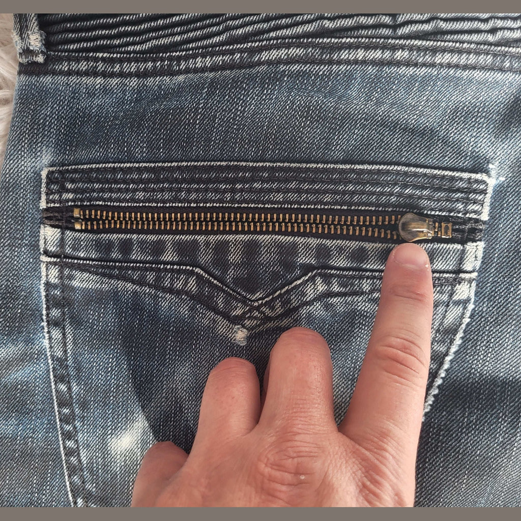 Jean bleu délavé, poche arrière zippée, taille non précisée, marque non visible Fripes Sélect