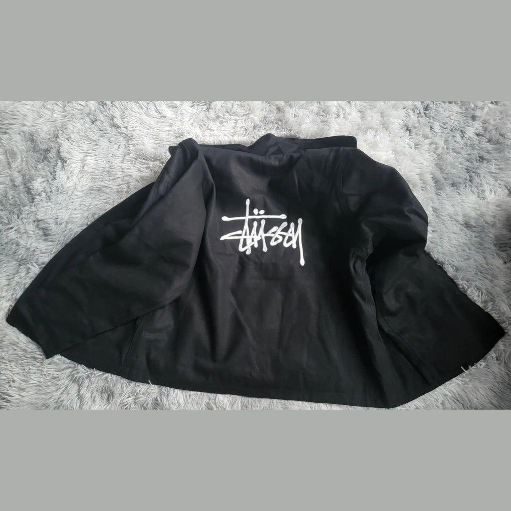 Veste noire Stüssy, logo blanc au dos, taille non indiquée. Fripes Sélect