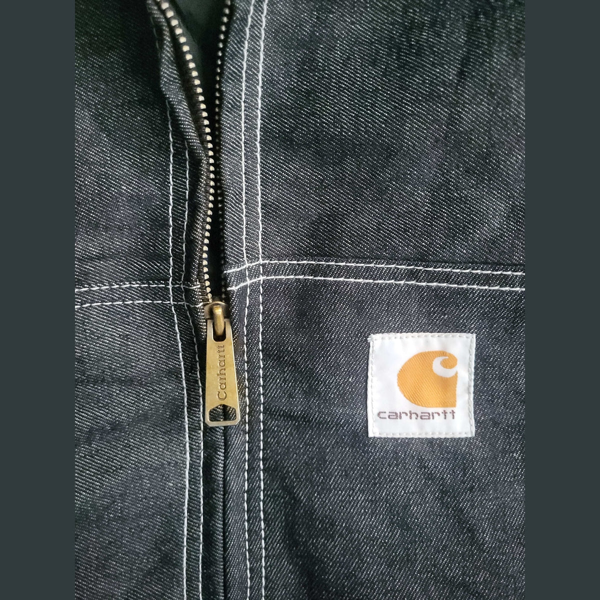 Veste Carhartt noire, taille non indiquée, fermeture éclair visible. Fripes Sélect