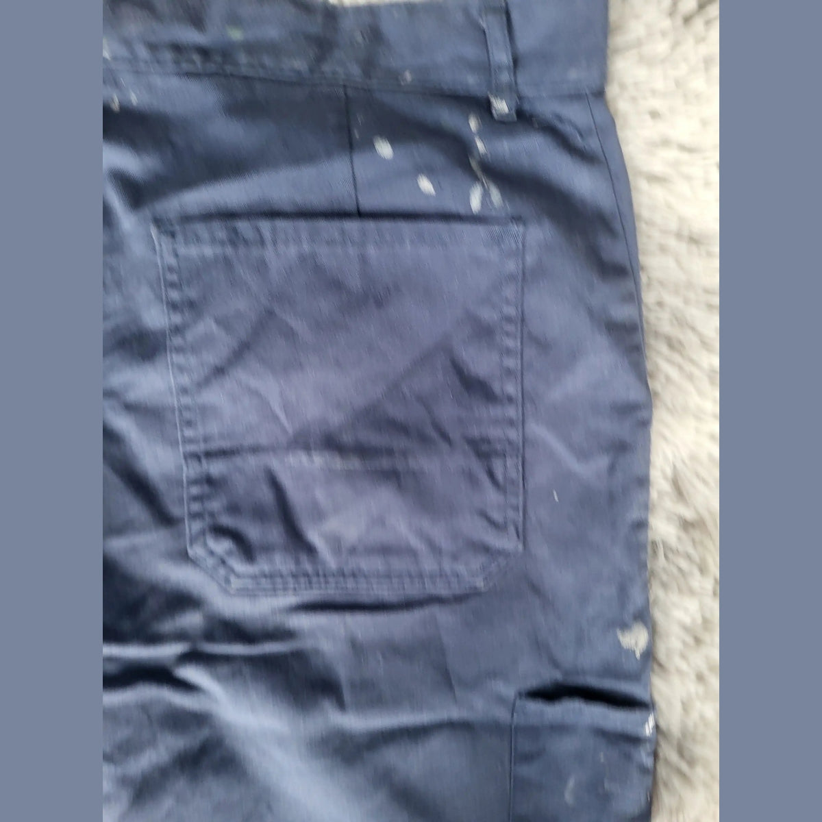 Pantalon de travail bleu marine avec taches de peinture, taille non visible, Fripes Sélect