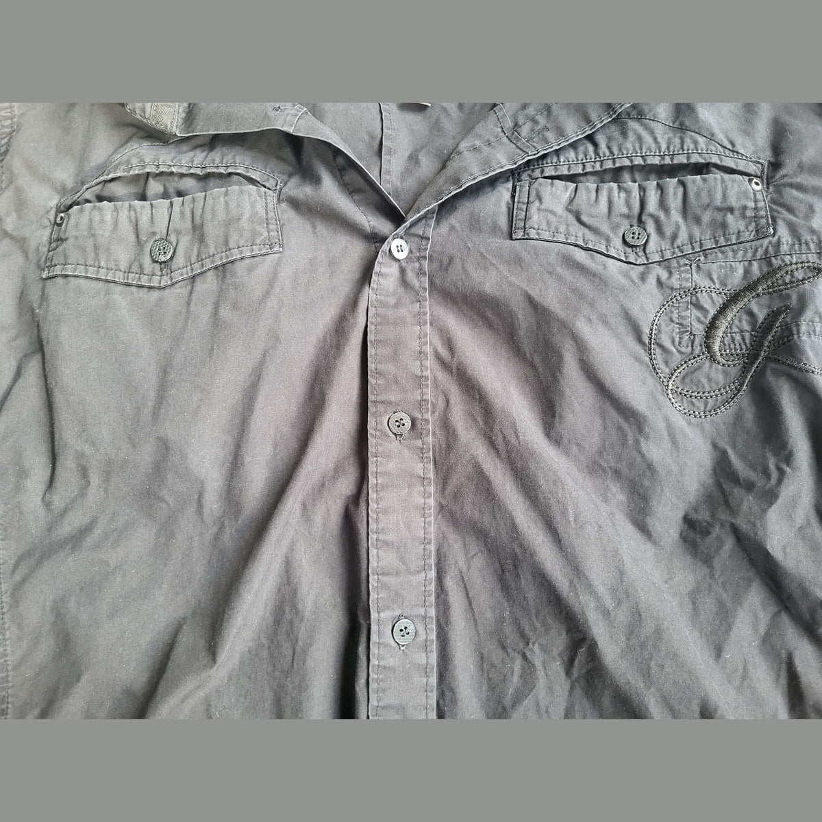 Chemise noire à manches longues, broderie lettre G, deux poches, taille non visible, Fripes Sélect