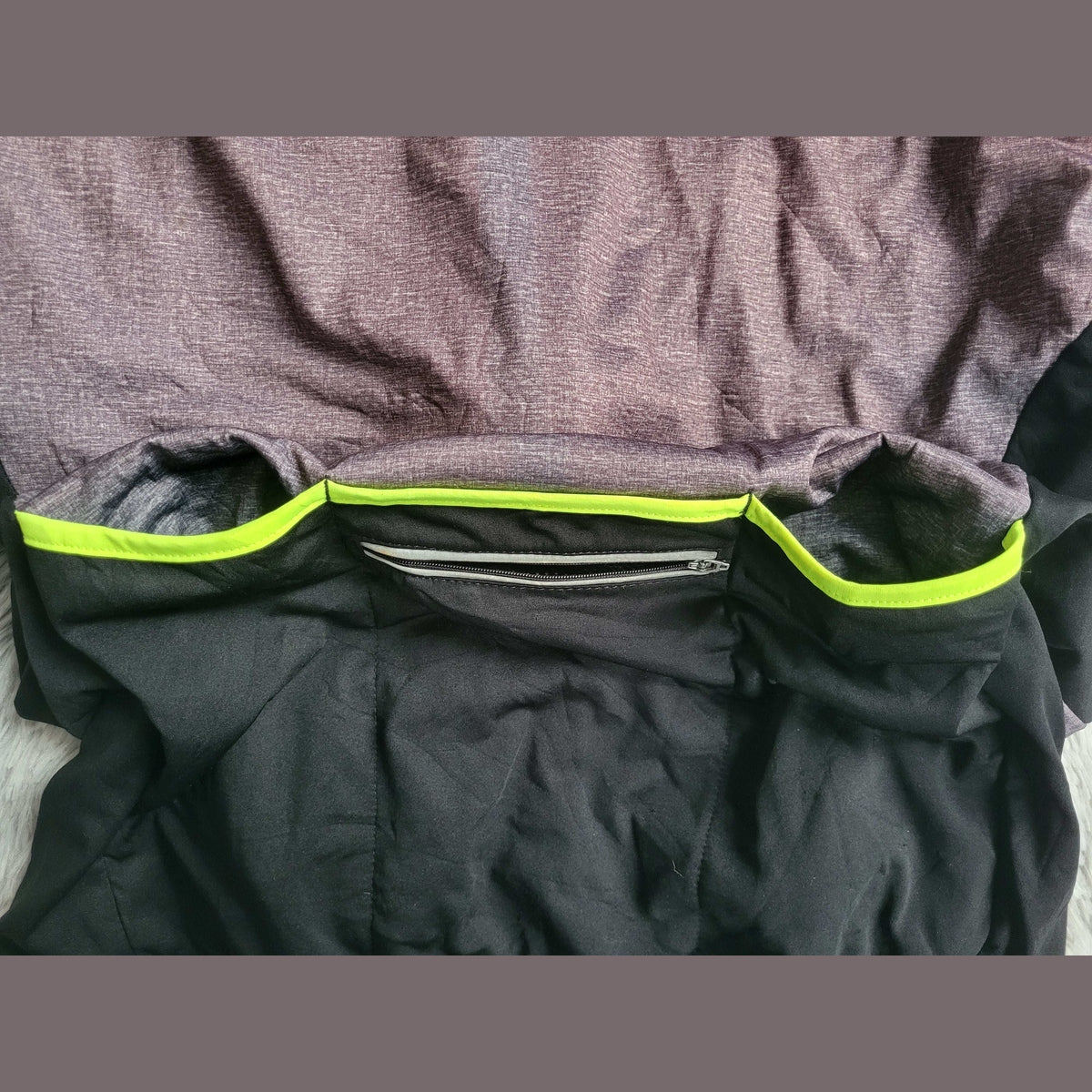 Maillot de sport noir et gris avec détails jaune fluo, poche arrière zippée, taille non visible. Fripes Sélect