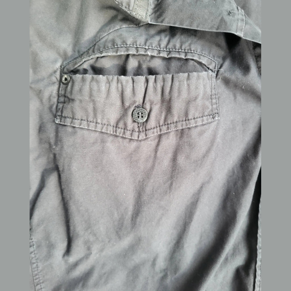 Chemise noire à poche boutonnée, marque et taille non visibles. Fripes Sélect