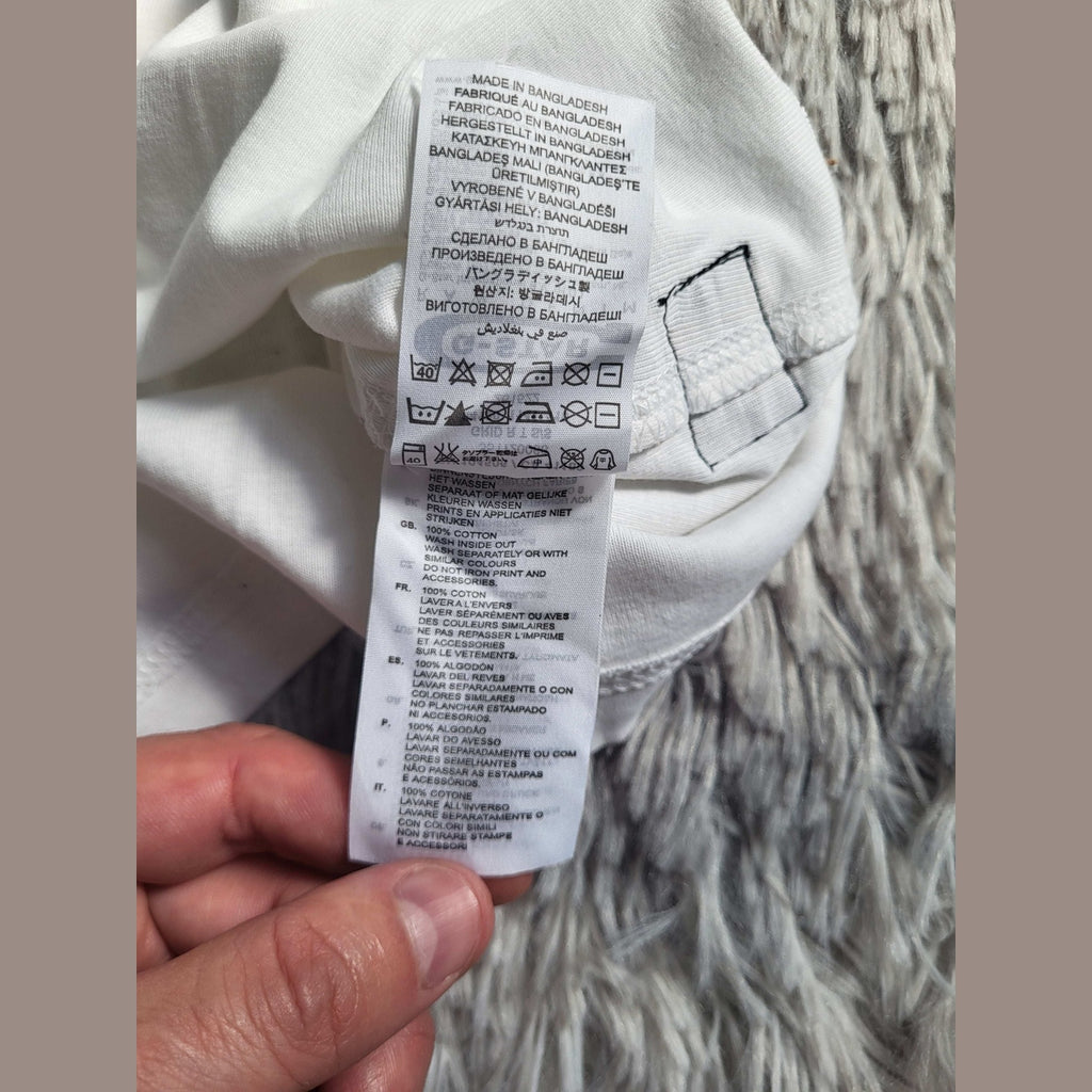 T-shirt blanc, 100% coton, taille non visible, étiquette d'entretien. Fripes Sélect