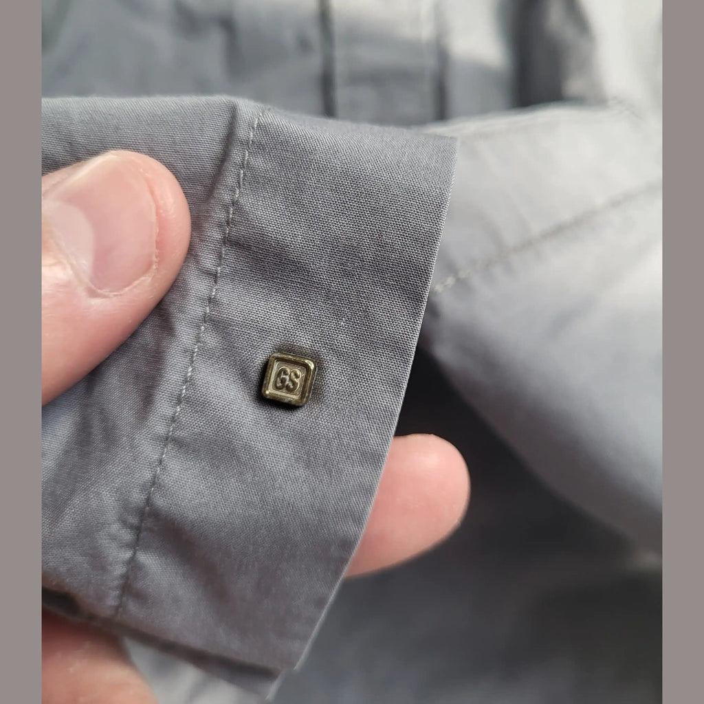 Chemise grise, marque GS visible sur la manche, taille non indiquée, Fripes Sélect
