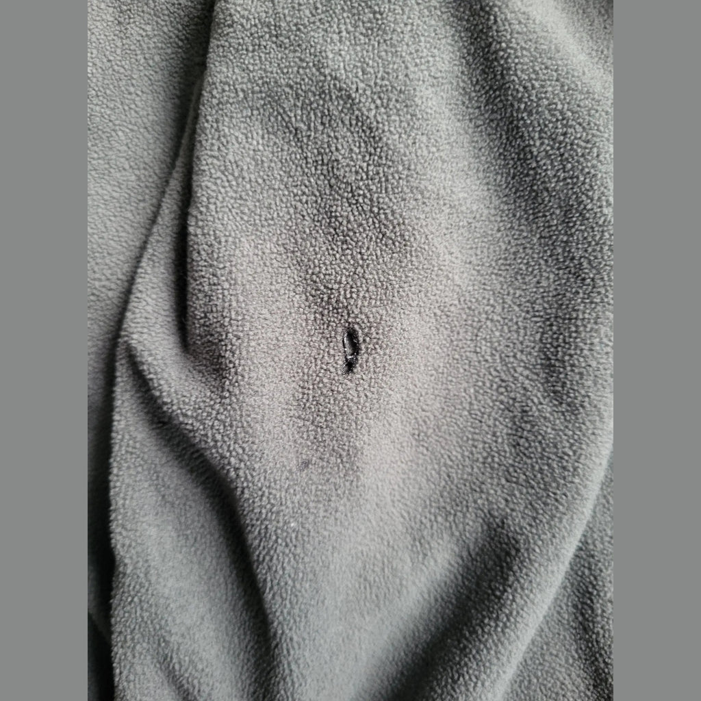 Veste polaire gris foncé, taille non visible, petite déchirure. Fripes Sélect