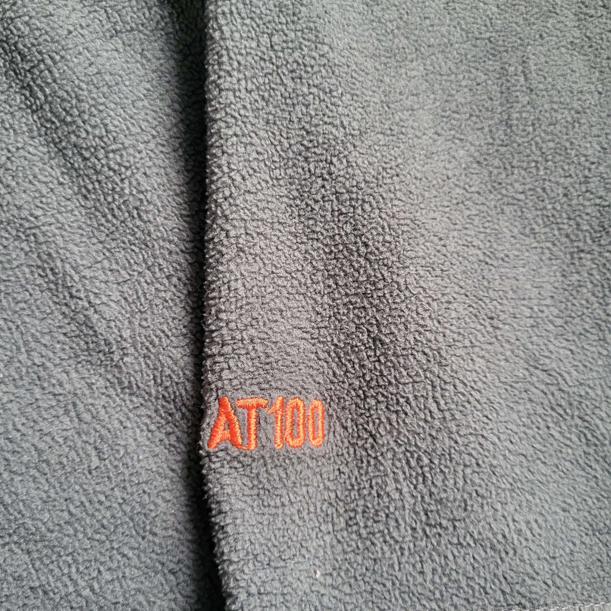 Veste polaire AT100 grise, taille non visible, broderie orange. Fripes Sélect