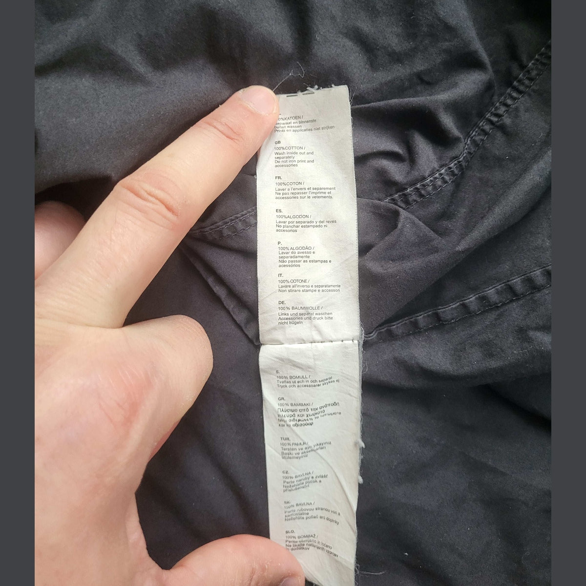 Étiquette de chemise noire 100% coton, taille non visible, aucune marque indiquée. Fripes Sélect
