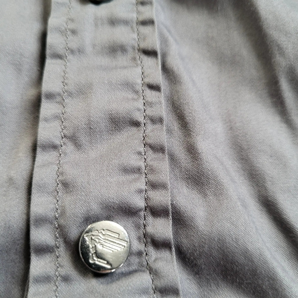 Chemise grise, marque non identifiée, boutons décoratifs, taille non visible. Fripes Sélect