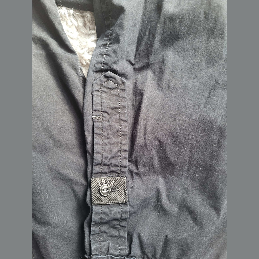 Veste noire, doublure en fausse fourrure, bouton marqué 1998, taille non visible. Fripes Sélect