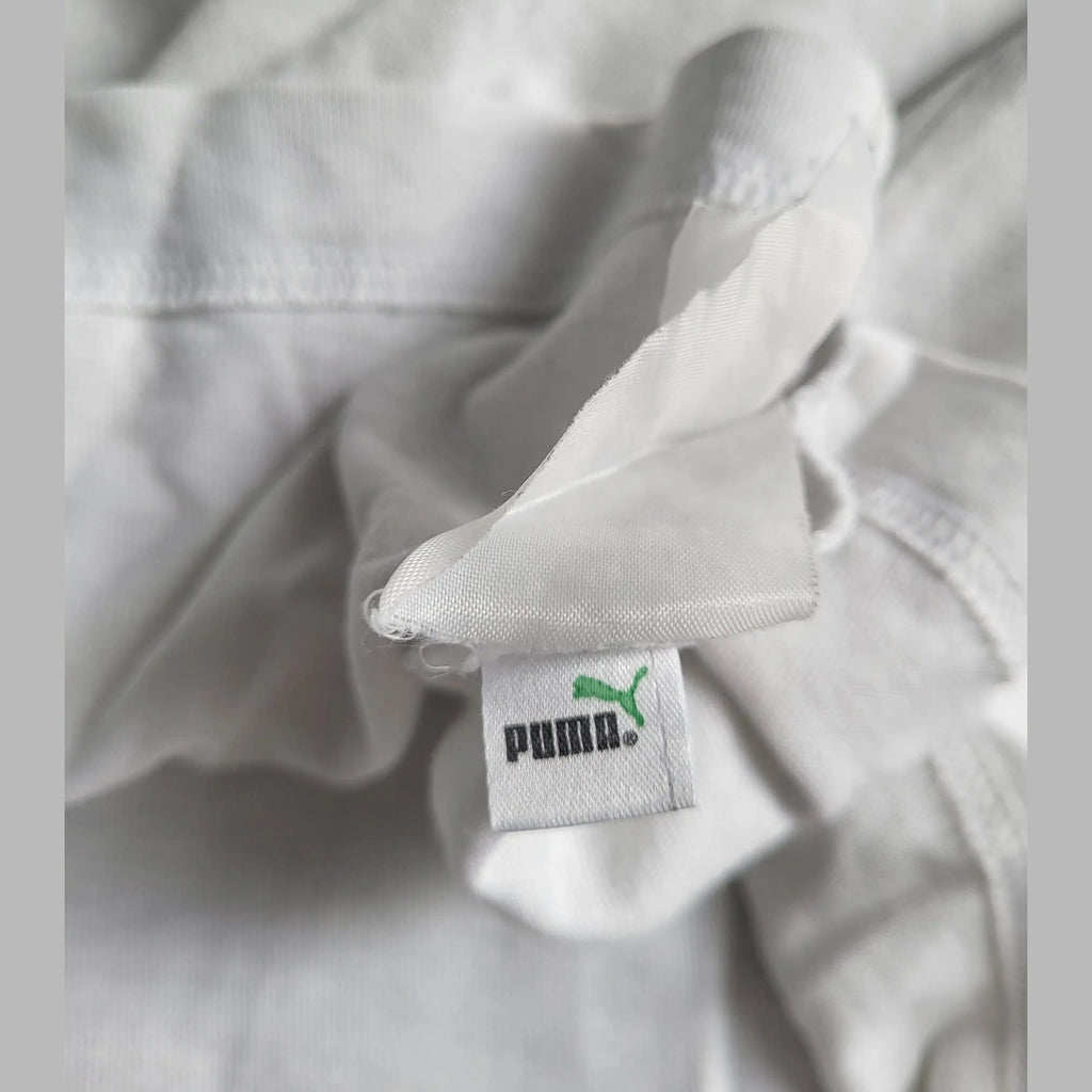 T-shirt Puma blanc, taille non visible, étiquette en gros plan. Fripes Sélect