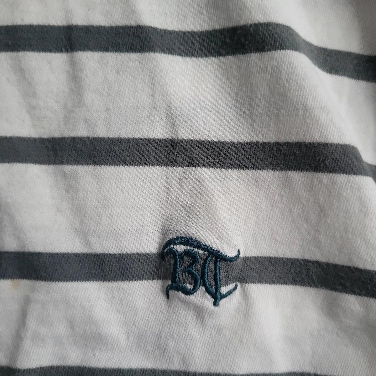 T-shirt à rayures blanches et grises, logo BT brodé, taille non visible. Fripes Sélect