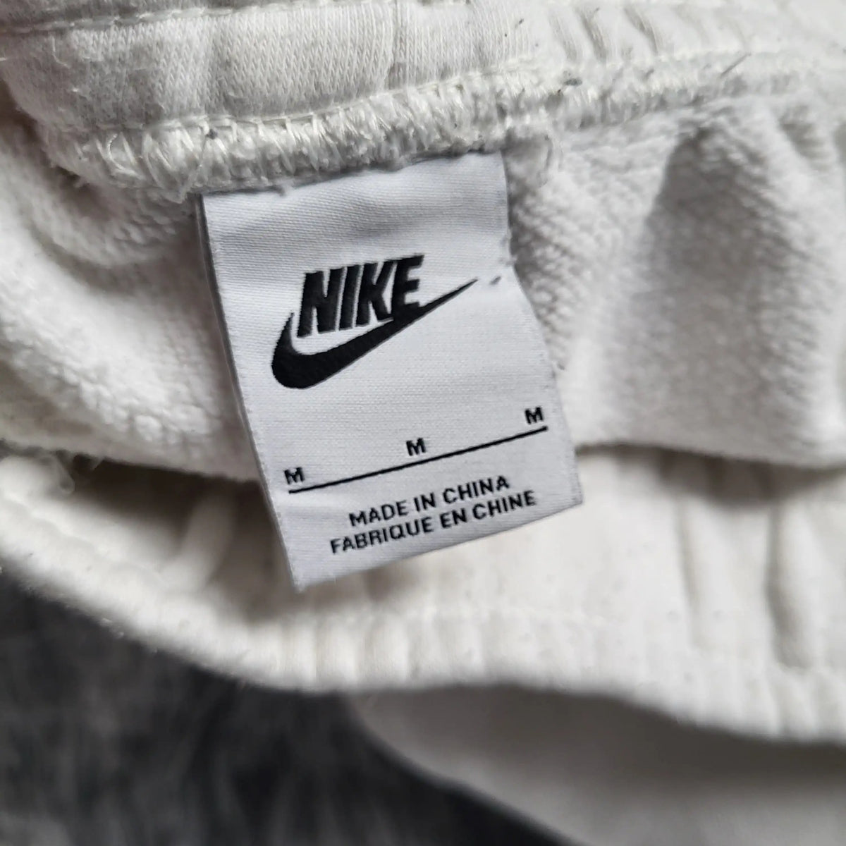 Sweat blanc Nike taille M, étiquette visible. Fripes Sélect