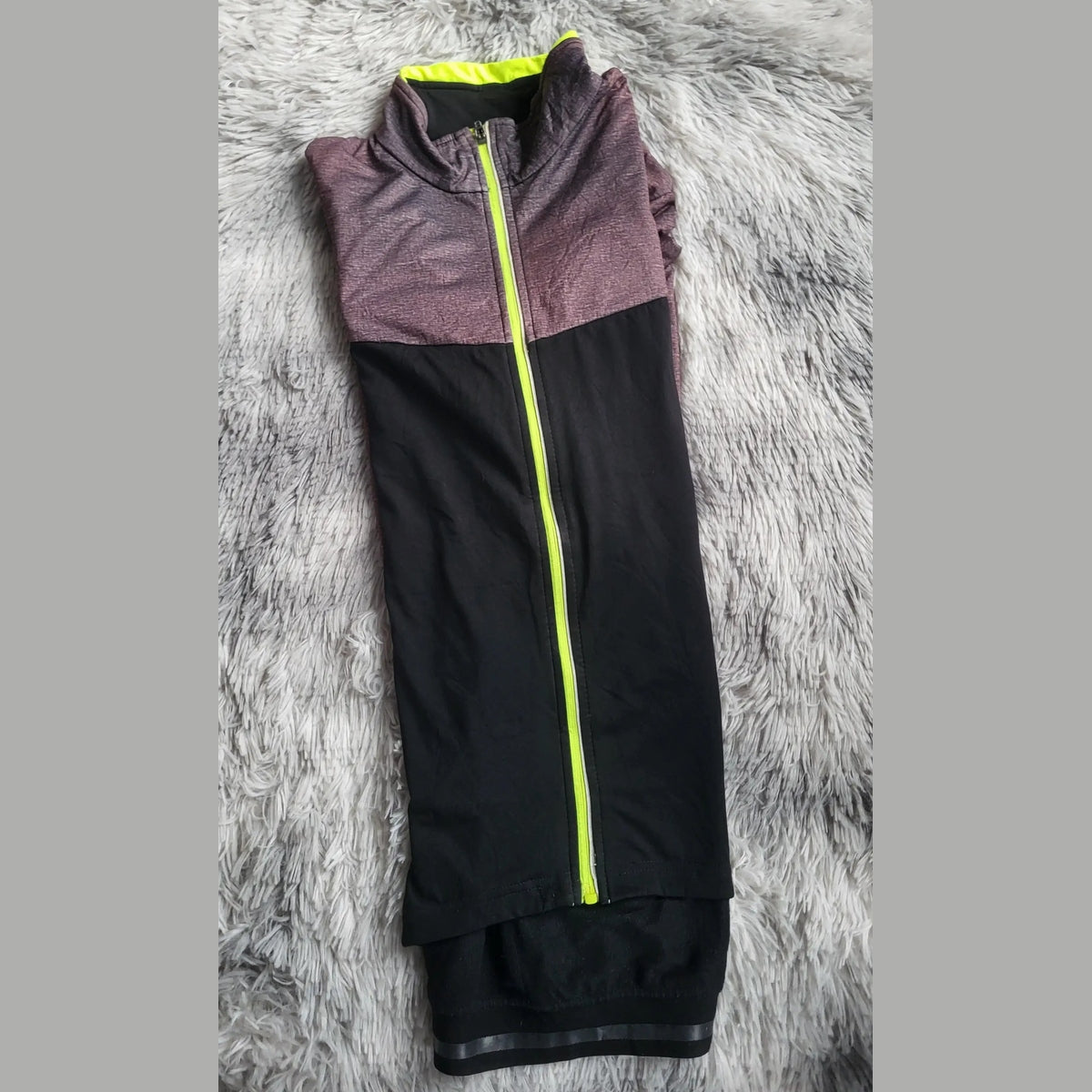 Veste de sport bicolore noir et violet, fermeture éclair jaune fluo, taille non indiquée. Fripes Sélect