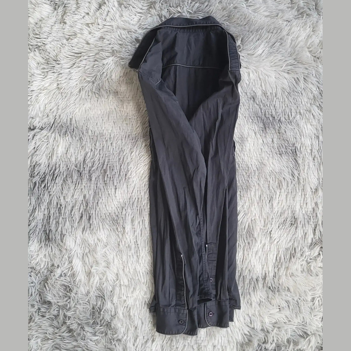Chemise noire, marque non visible, taille non indiquée, posée à plat. Fripes Sélect