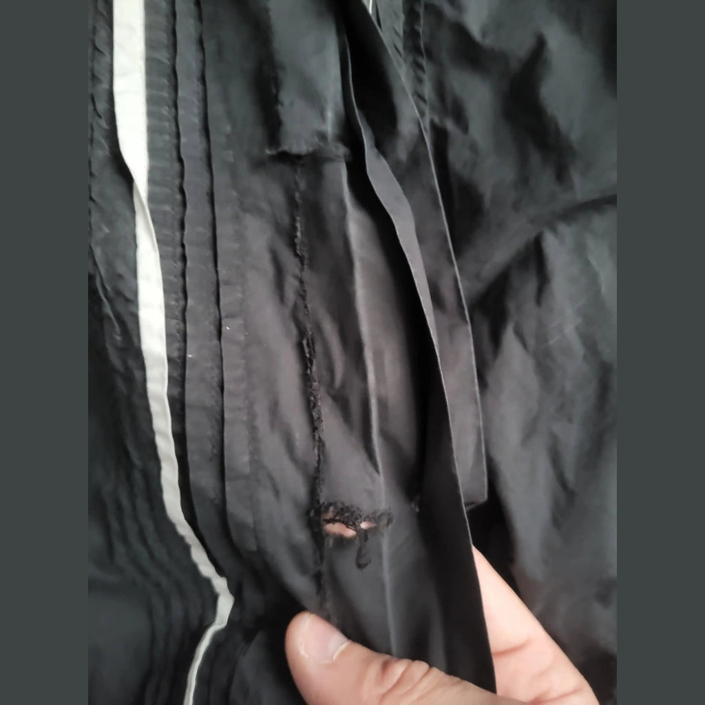 Veste noire, marque non visible, trou sur le côté, taille non indiquée. Fripes Sélect