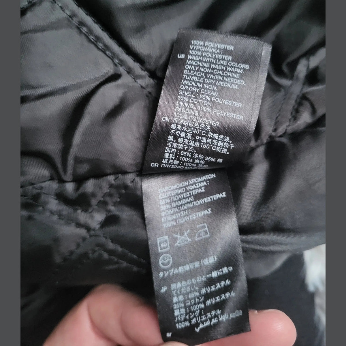 Veste noire, étiquette intérieure, composition 65% polyester 35% coton, taille non visible, Fripes Sélect