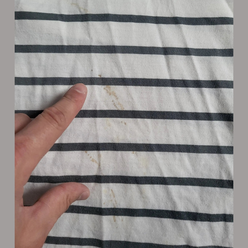 T-shirt rayé blanc et noir, tache visible, taille non indiquée, marque non visible. Fripes Sélect