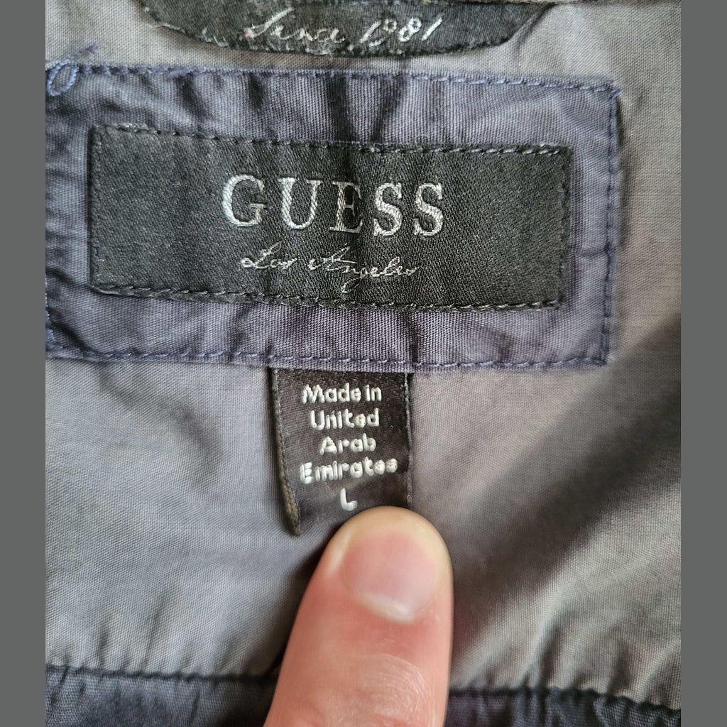 Veste grise Guess taille L, étiquette visible. Fripes Sélect