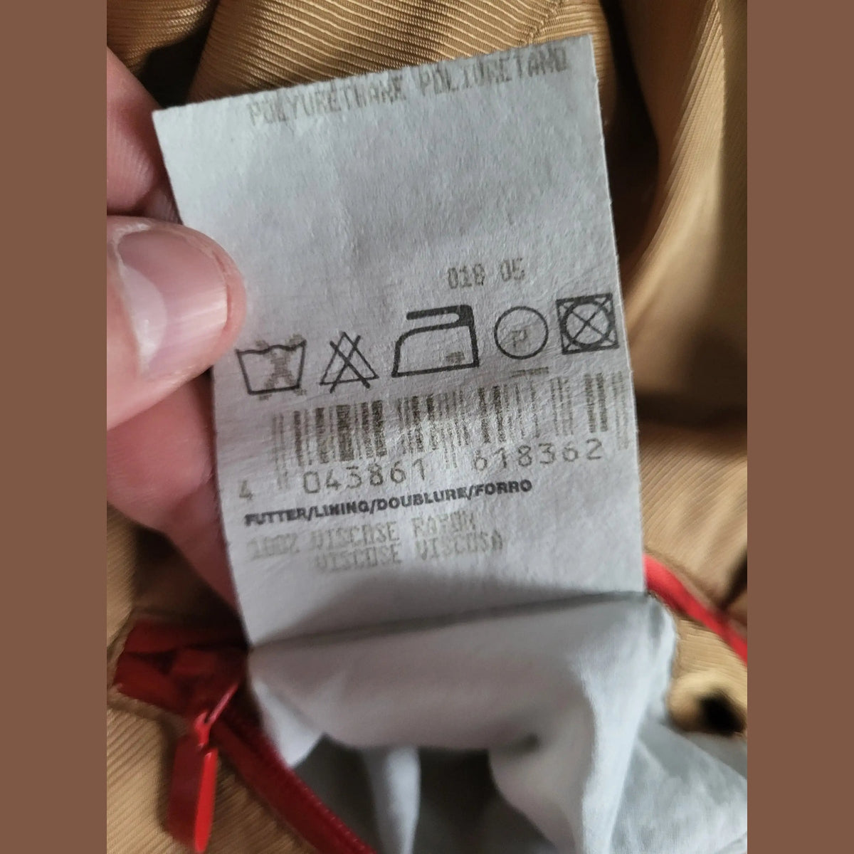 Étiquette d'entretien d'un vêtement beige, marque et taille non visibles. Fripes Sélect