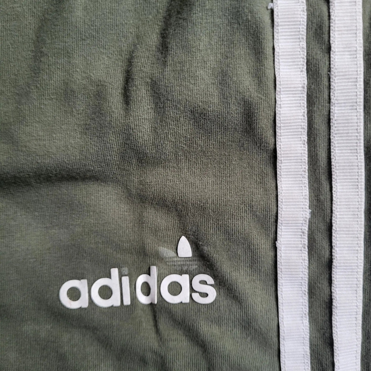 Pantalon Adidas vert kaki à bandes blanches, taille non visible, Fripes Sélect