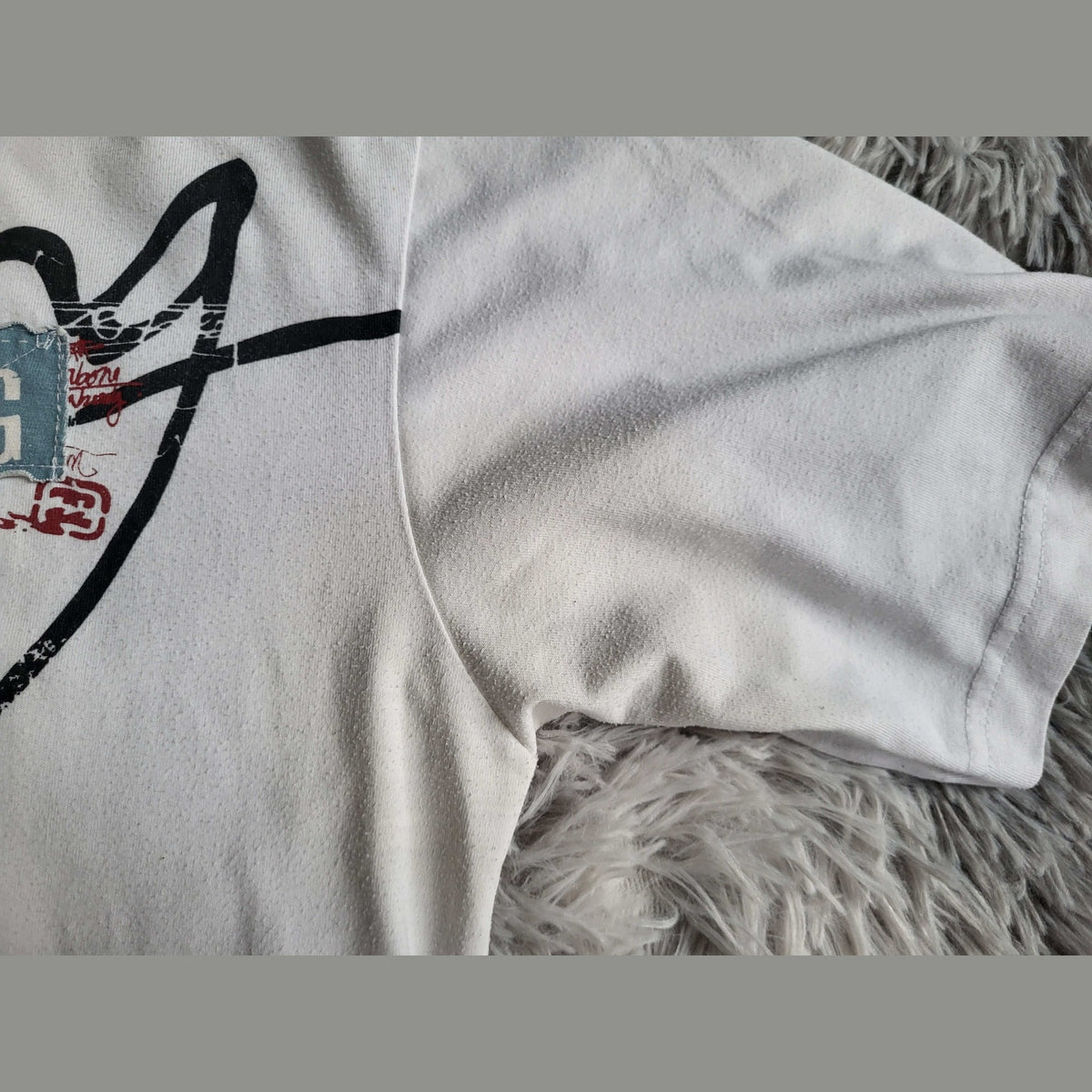 T-shirt blanc à motifs graphiques, marque et taille non visibles. Fripes Sélect