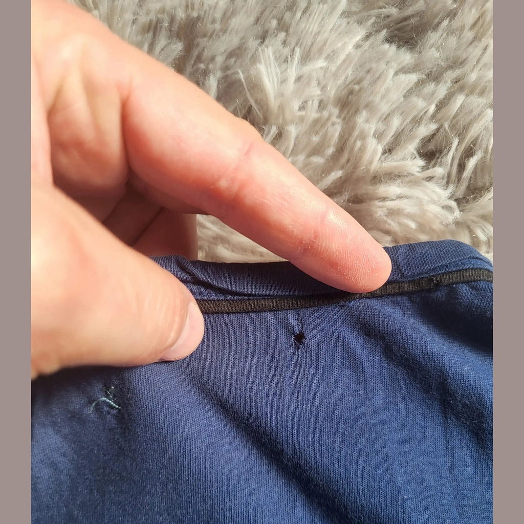 T-shirt bleu, marque et taille non visibles, détail col et petit trou. Fripes Sélect