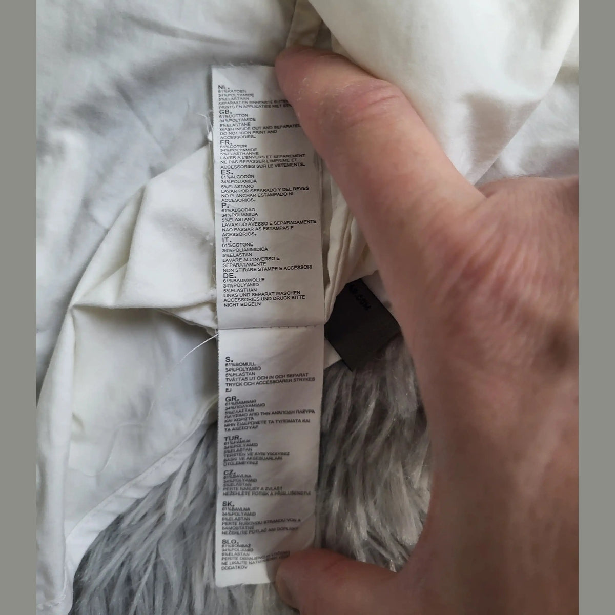 Étiquette d’entretien d’un vêtement blanc, marque et taille non visibles, Fripes Sélect