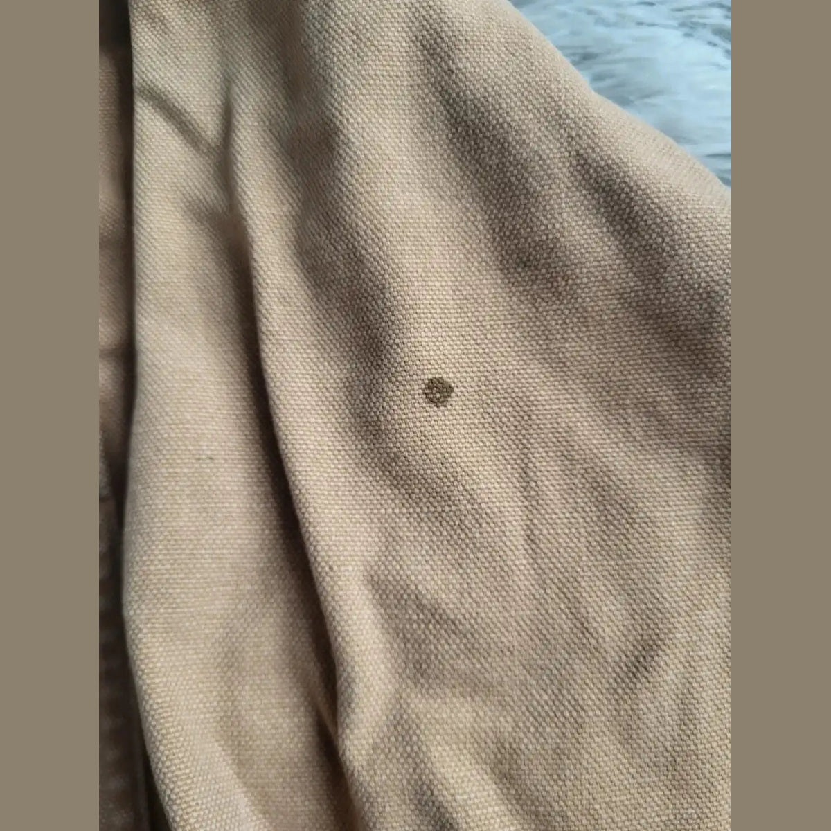 Pantalon beige, marque et taille non visibles, petite tache sur le tissu. Fripes Sélect